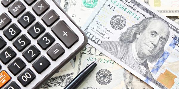 Top view of calculator and pen on American Dollars cash.