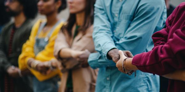 Portrait of group of activists holding hands in the street.